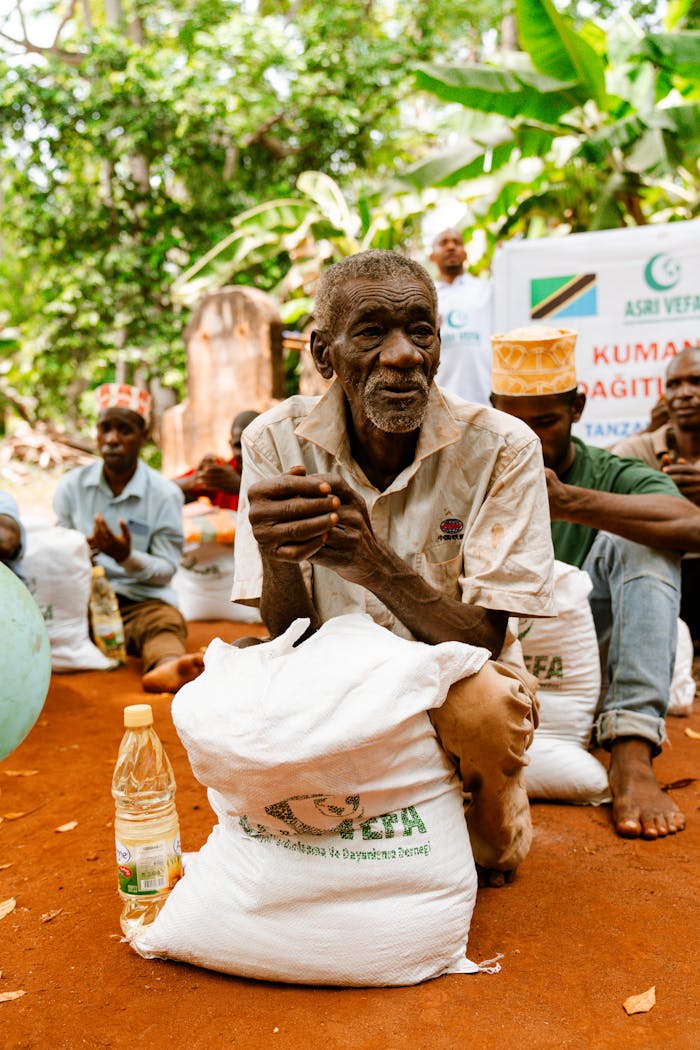 services-01 An elderly man with a food package during a distribution event in a rural setting.